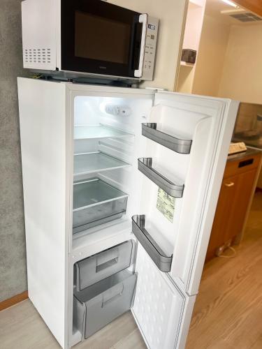 an open refrigerator with a microwave on top of it at VESSEL Inn in Fukuoka