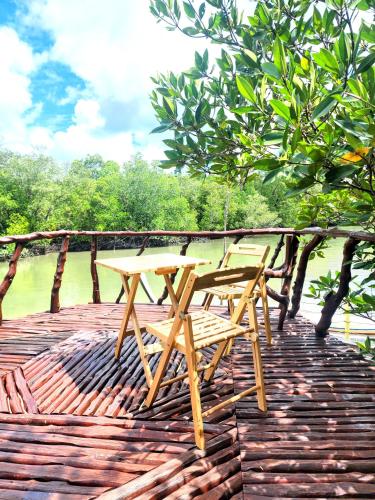 a wooden picnic table sitting on top of a wooden deck at Phang Nga Bay Khanittha Homestay in Ban Khiam
