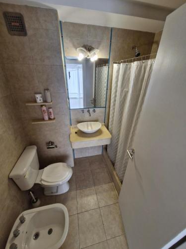 a bathroom with a toilet and a sink and a mirror at Consorcio 9 de Julio in San Juan