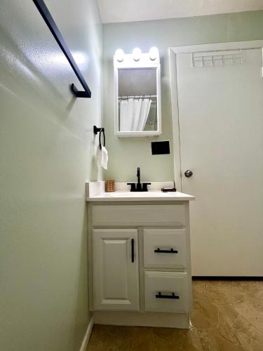 a white bathroom with a sink and a mirror at Guest Studio in Gainesville