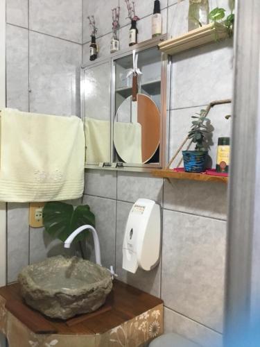 a bathroom with a sink and a mirror and a toilet at Refúgio Cataratas by Grasi in Foz do Iguaçu
