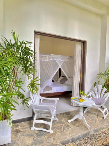 a bedroom with a bed and a table and a mirror at White Resort - 1 Min walk to the Beaches in Tangalle