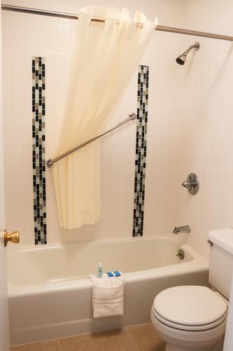 a bathroom with a white tub and a toilet at Chaparral Motor Inn in Burlington