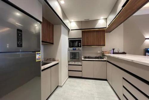 a large kitchen with white counters and stainless steel appliances at Randooo hoo in Kafr El-Shaikh