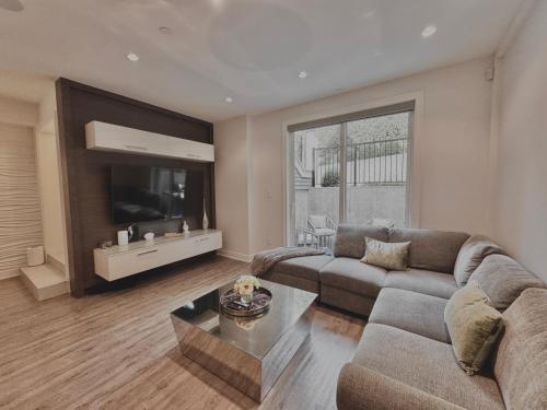 a living room with a couch and a tv at Kitsilano Retreat at Private 3 Bed with Parking and BBQ in Vancouver