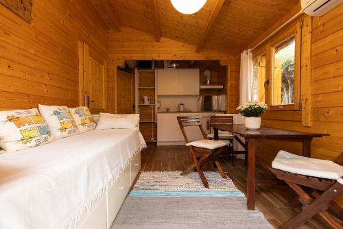 a bedroom with a bed and a table and a kitchen at Cabana a 15 minutos do Guincho in Alcabideche