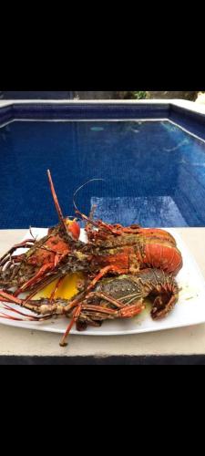 a plate of lobster sitting on a table at Cabina con Piscina in Puntarenas