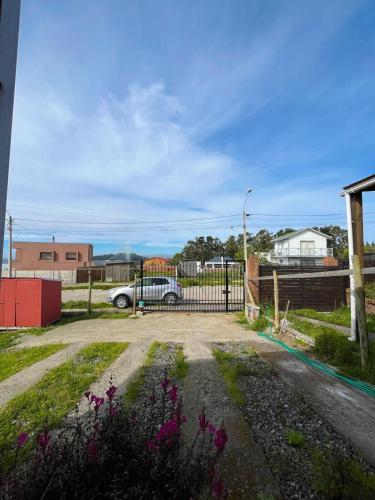 a fence with a car parked in a parking lot at Cabañas Mongetum in Constitución