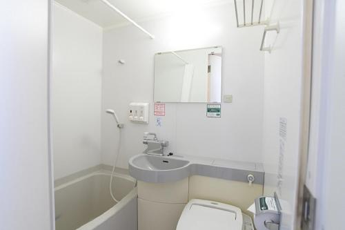 a white bathroom with a sink and a toilet at Washington R&BHotel TokyoToyocho in Tokyo