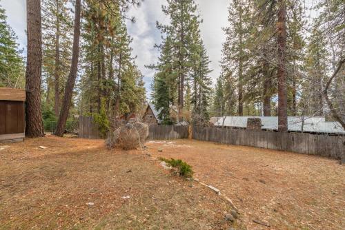 a yard with a fence and trees and a house at Lakeside Serenity Retreat in Kings Beach