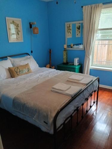 a bedroom with a large bed with blue walls at Pensacola hidden gem cottage 3 minutes from Navy Base, pet friendly in Pensacola