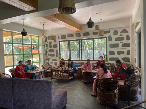 un grupo de personas sentadas en mesas en un restaurante en Escape by feel good, en Pokhara