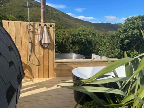 a wooden deck with a bath tub and a hot tub at Apple Valley West - Mahana in Mahana
