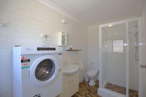 a bathroom with a washing machine and a toilet at Alpha Centauri - 8 - 39 Gippsland Street in Jindabyne