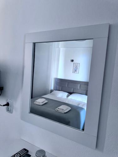 a mirror reflecting a bed in a bedroom at Sevilia Rooms in Qeparo