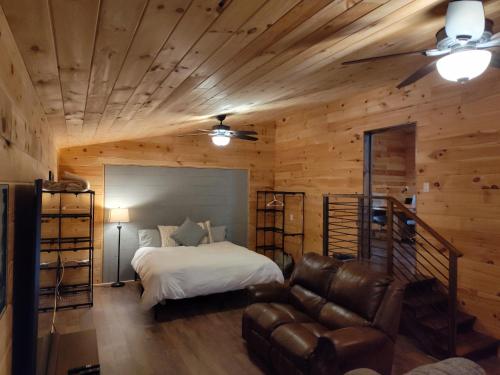 a bedroom with a bed and a leather couch at TheGapCabin in Buffalo Gap