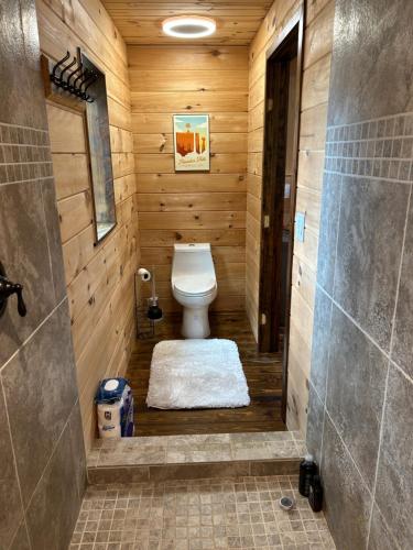 a bathroom with a toilet in a wooden room at TheGapCabin in Buffalo Gap