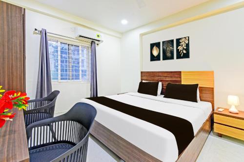 a bedroom with a large bed and two chairs at Super Townhouse Kondapur Near Botanical Garden Formerly RRR Inn in Hyderabad