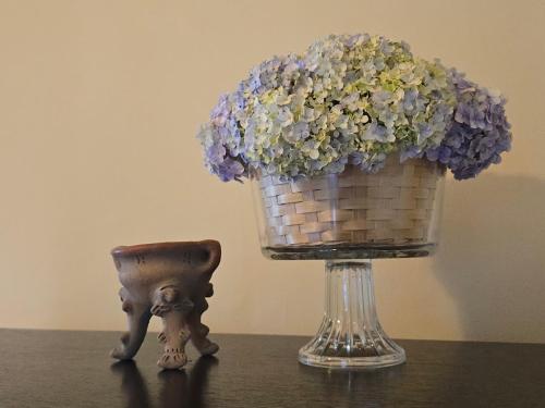 a basket of flowers on a table next to a vase at El Santuario Ecolodge in Boquete