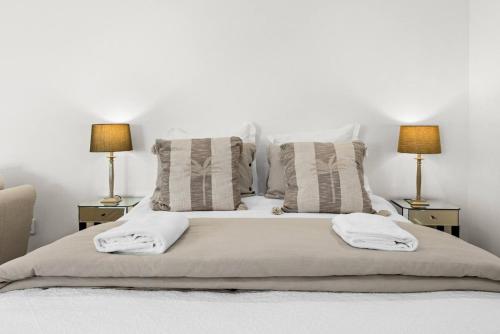 ハブロック・ノースにあるPeaceful Escape Close to Town - The Sanctuary Studioの白いベッド(2つのテーブルにランプ2つ付)