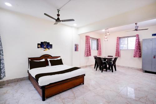 a bedroom with a bed and a table with chairs at Hotel O Moonlight Residency in Mumbai