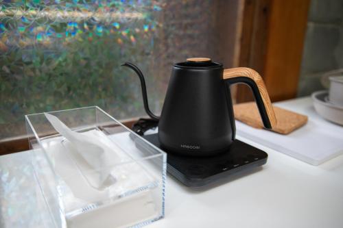 a black kettle sitting on a table with a plastic container at 香琉 Kaoru in Miyako Island