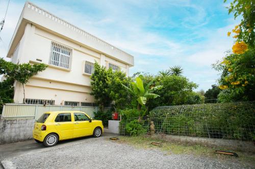 a yellow car parked in front of a house at 香琉 Kaoru in Miyako Island