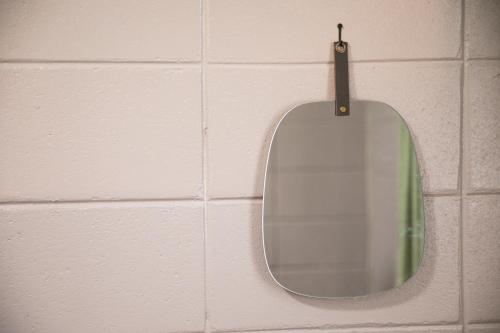 a mirror hanging on a wall in a bathroom at 香琉 Kaoru in Miyako Island