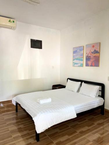 a bedroom with a large white bed with two pillows at Horizon Homestay in Phong Nha