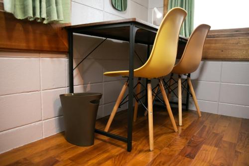 a table with two yellow chairs under it at 香琉 Kaoru in Miyako Island