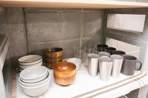 a shelf with cups and plates and bowls on it at 香琉 Kaoru in Miyako Island