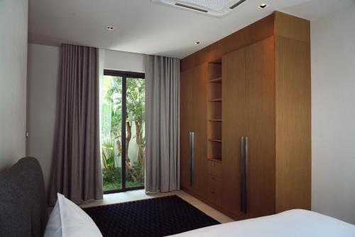1 dormitorio con un gran armario de madera y una ventana en Luxurious villa By IBG Property, en Ban Pak Lak