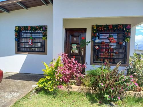 a house with two windows and flowers in front of it at Casa via Boquete in Alto Boquete