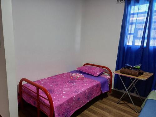 a small room with a small table and a purple bed at Casa via Boquete in Alto Boquete