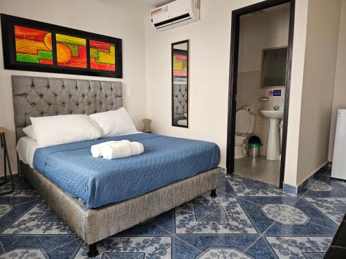 a bedroom with a bed with a blue comforter at Caribbean Island Hotel Piso 2 in San Andrés