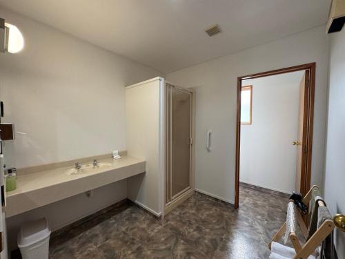 a bathroom with a sink and a shower at ASURE Ambassador Motor Lodge in Oamaru