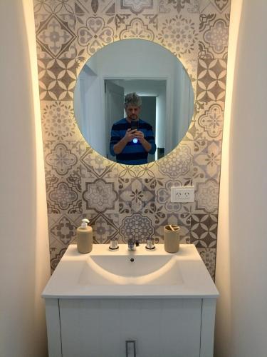 a man taking a picture of a bathroom mirror at El mejor depto de Villegas in General Villegas