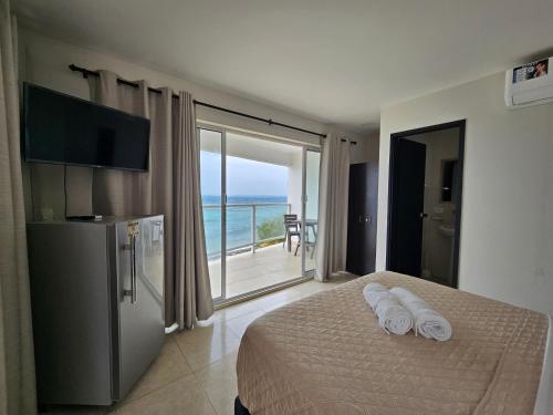 a bedroom with a bed and a view of the ocean at Caribbean Island Hotel Piso 2 in San Andrés