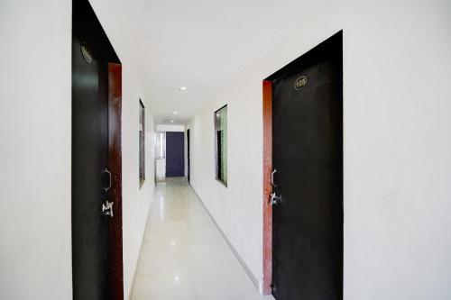 斋浦尔HOTEL O HOLIDAYS INN的走廊上设有两个黑色的门和白色的墙壁
