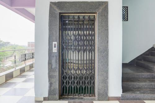a metal door on a building with stairs at Hotel O Happy Inn in Raipur