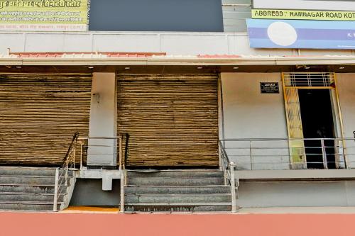 a building with two doors and stairs in front at Hotel O Happy Inn in Raipur