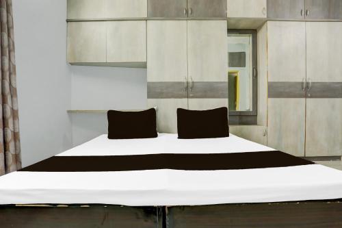 a large bed with two pillows on top of it at Hotel O Happy Inn in Raipur