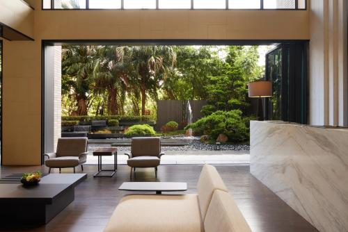 a living room with a couch and chairs at Yun Estate Hotel in Tamsui
