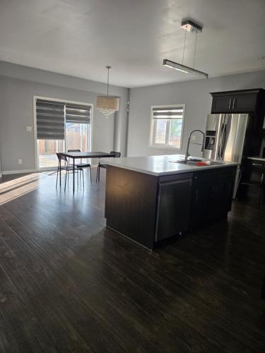 an empty living room with a kitchen and a table at Devanshire stay in Winnipeg