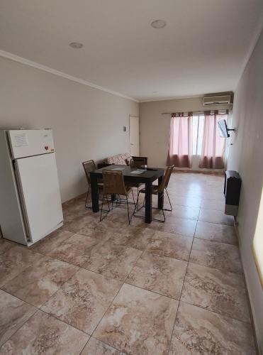a dining room with a table and a refrigerator at Depto Civora 3 in Villa Regina