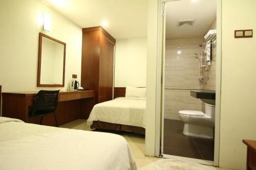 Habitación de hotel con 2 camas y aseo en AG Hotel Penang, en George Town