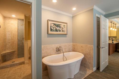 een wit bad in een badkamer met een douche bij RiverWalk Resort at Loon Mountain in Lincoln