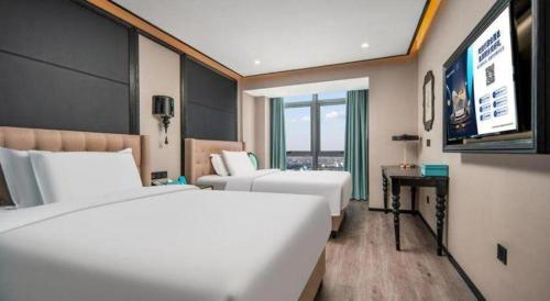 a hotel room with two beds and a flat screen tv at Xana Hotelle Nanchang Gaoxin Xincheng Wuyue Plaza in Nanchang