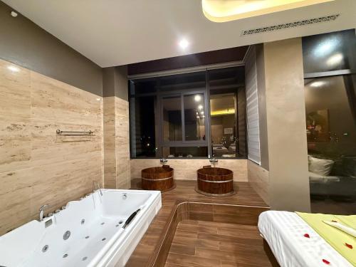 a bathroom with a bath tub and a large window at MD Hotel in Mỹ Lộc