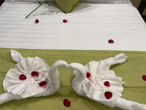 two towels shaped like elephants on a bed with hearts at MD Hotel in Mỹ Lộc